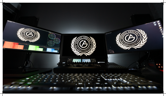 Color grading suite with three reference monitors above the grading panel