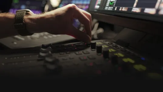 Hands on a mixing console in a sound finishing stage